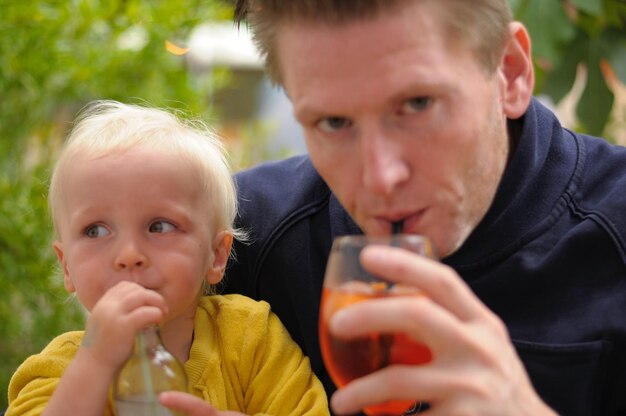 Nahaufnahme von Vater und Sohn beim Trinken im Freien