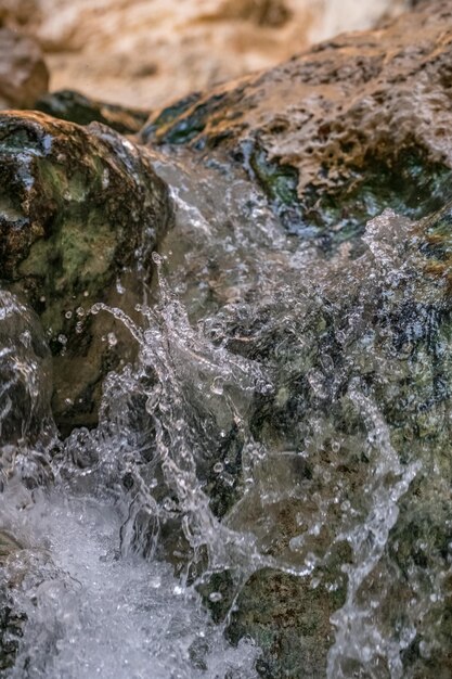 Foto nahaufnahme von wasser, das durch felsen fließt