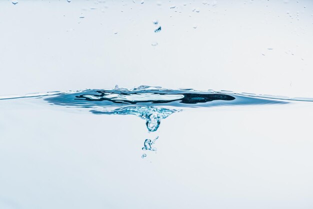 Foto nahaufnahme von wasser, das gegen blauen hintergrund spritzt