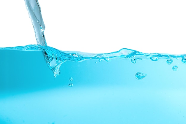 Nahaufnahme von Wasser, das gegen blauen Hintergrund spritzt