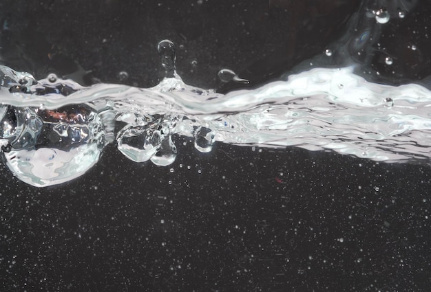 Nahaufnahme von Wasser, das gegen schwarzen Hintergrund spritzt