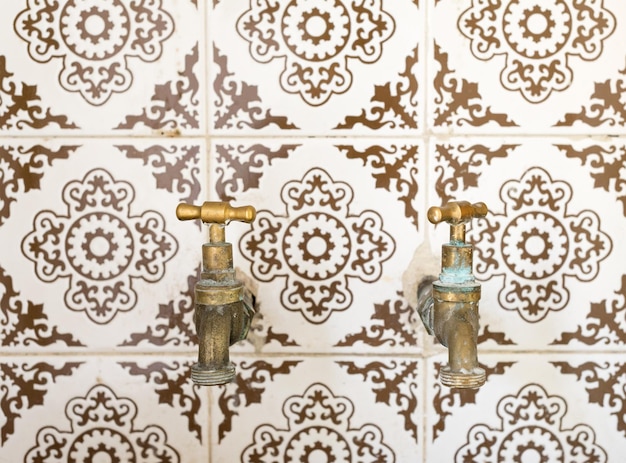 Nahaufnahme von Wasserhahnen an einer Fliesenwand