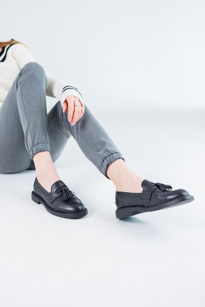 Nahaufnahme von weiblichen Beinen in Hosen und klassischen Schuhen aus schwarzem Leder Bequeme Sommerschuhe für Damen Neue Frühjahrskollektion von Lederschuhen für Damen 2023