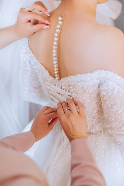 Nahaufnahme von weiblichen Händen, die sich berühren, Kleid, Maniküre für Frauen, ein luxuriöser Ehering an einem Finger einer Frau