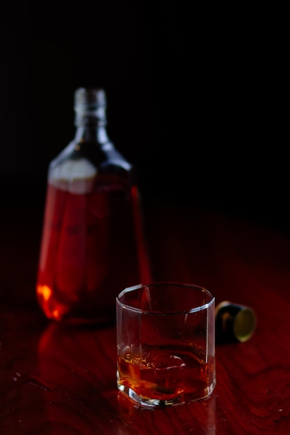 Nahaufnahme von Whiskey auf dem Tisch vor schwarzem Hintergrund