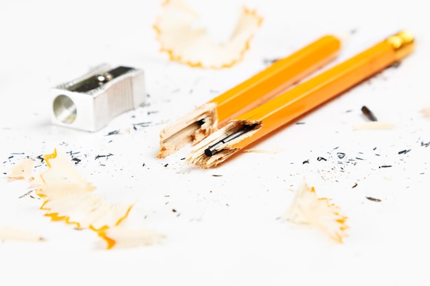 Foto nahaufnahme von zerbrochenen bleistiften mit dem schärfer und spänen auf dem tisch