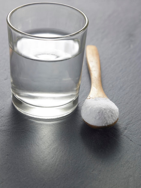 Nahaufnahme von Zuckerpulver mit Wasser in Trinkglas auf dem Tisch
