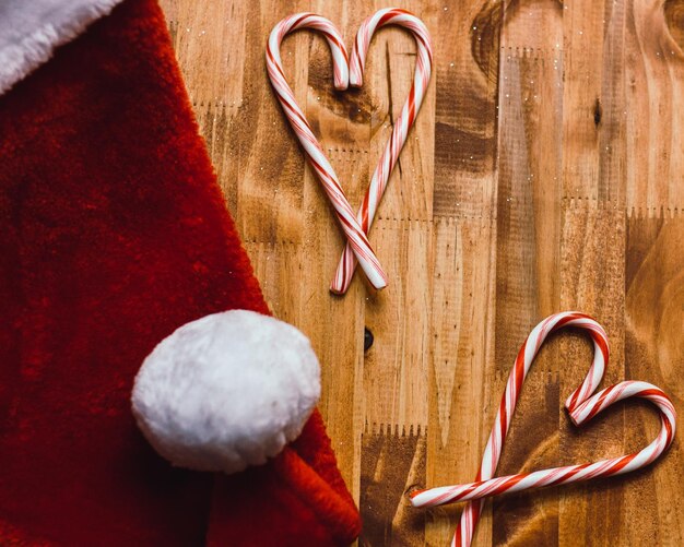 Nahaufnahme von Zuckerstäbchen mit Weihnachtsmannshut auf dem Tisch