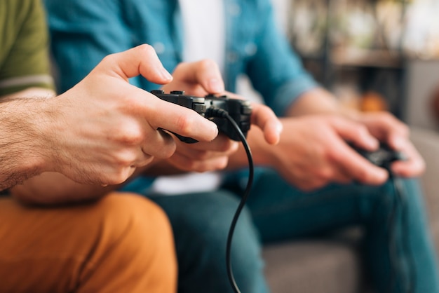 Foto nahaufnahme von zwei jungen männern, die einen schwarzen gamecontroller halten