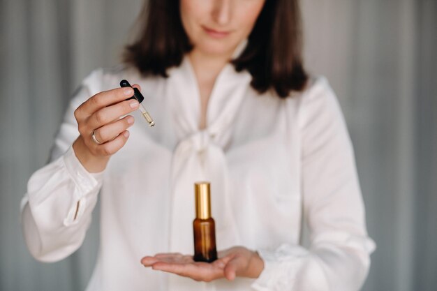 Nahaufnahme weiblicher Hände, die eine Flasche Aromatherapie mit ätherischen Ölen halten