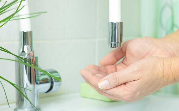 Nahaufnahme weiblicher Hände, die sich vor dem Waschen mit Seife einseifen