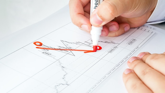 Nahaufnahmeansicht des Geschäftsmannes, der abnehmendes Finanzdiagramm oder -diagramm zeichnet. Konzept der globalen Finanzkrise und Insolvenz.