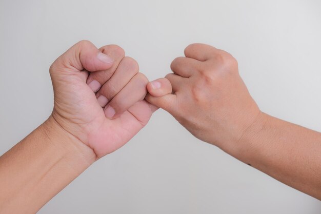 Nahaufnahmeaufnahme von zwei Händen, die kleine Finger einhaken