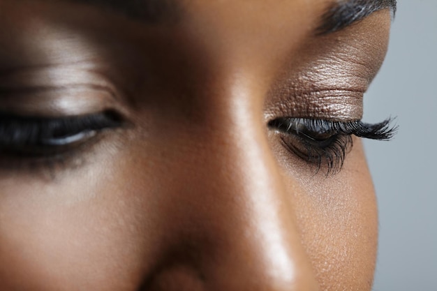 Nahaufnahmebild der Augen der schwarzen Frau mit nacktem Make-up