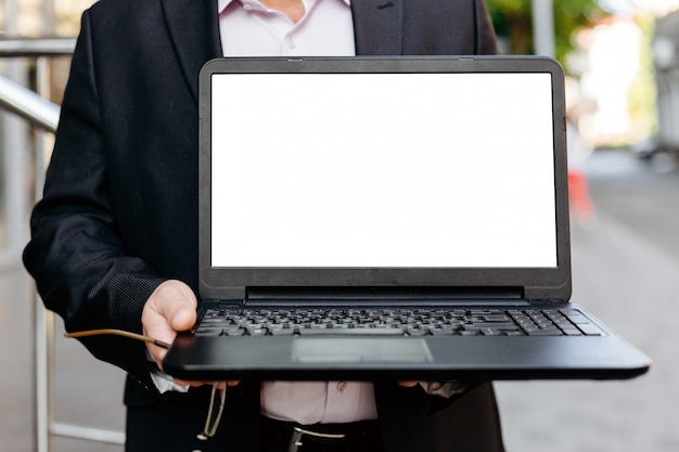 Nahaufnahmebild des Geschäftsmannes offenen Laptop, leeren weißen leeren Bildschirm halten