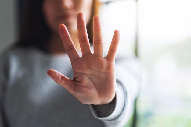 Nahaufnahmebild einer ausgestreckten Hand einer Frau und mit Stopphandzeichen