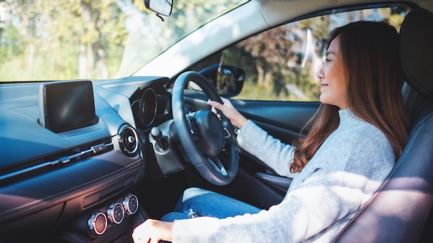 Nahaufnahmebild einer Fahrerin, die beim Autofahren den automatischen Schalthebel schaltet