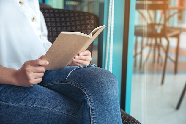 Nahaufnahmebild einer Frau, die ein Buch hält und liest