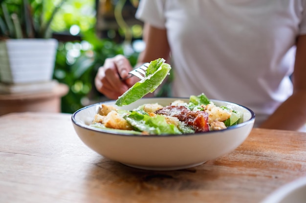 Nahaufnahmebild einer Frau, die einen Caesar-Salat isst