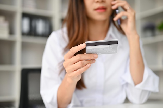 Nahaufnahmebild einer jungen asiatischen Frau kontaktiert einen Kreditkarten-Callcenter-Service