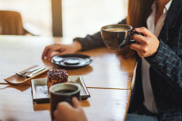 Nahaufnahmebild von Frauen genossen es, Dessert zu essen und Kaffee zusammen im Café zu trinken?