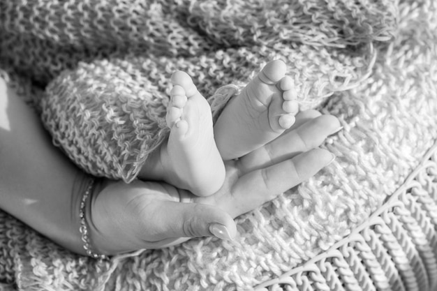 Nahaufnahmebild von neugeborenen Babyfüßen auf gestricktem Plaid