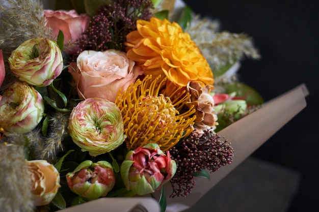 Nahaufnahmeblumenstrauß verziert in der Weinleseart auf einem dunklen Hintergrund, selektiver Fokus