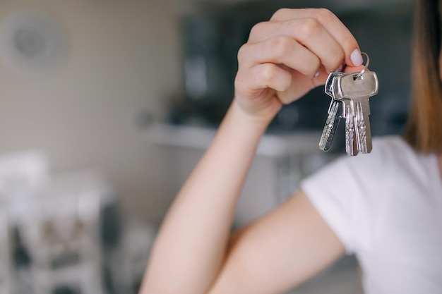 Nahaufnahmefoto der Frau, die Schlüssel von der neuen Wohnung hält