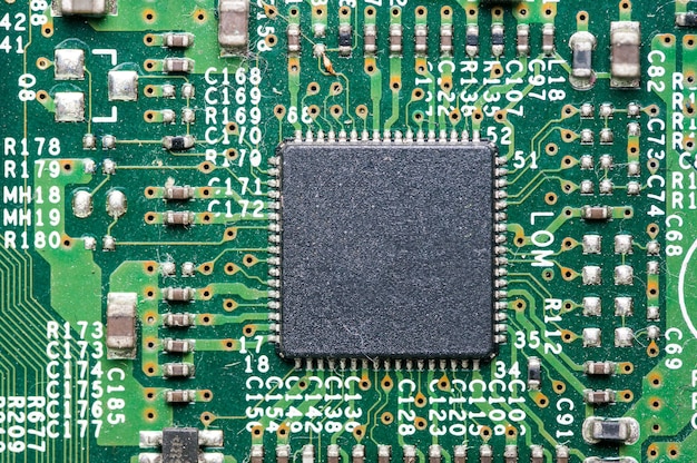 Nahaufnahmefoto der grünen ComputerLeiterplatte und des Computerchips in der Mitte.