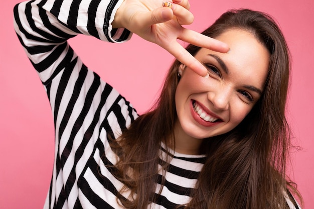 Nahaufnahmefoto der jungen europäischen positiven lächelnden gewinnenden glücklichen schönen Brunettefrau mit aufrichtigem