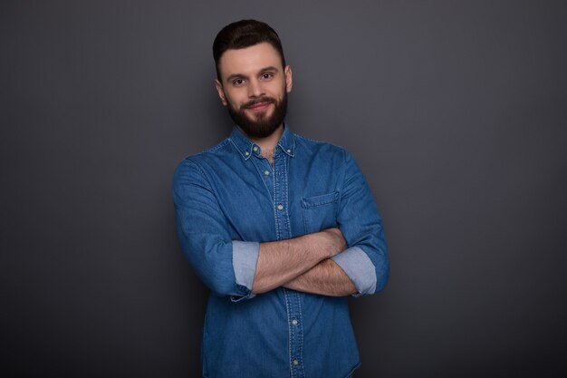 Nahaufnahmefoto des aufgeregten glücklichen jungen modernen bärtigen Hipster-Mannes in den Jeans tragen isoliert