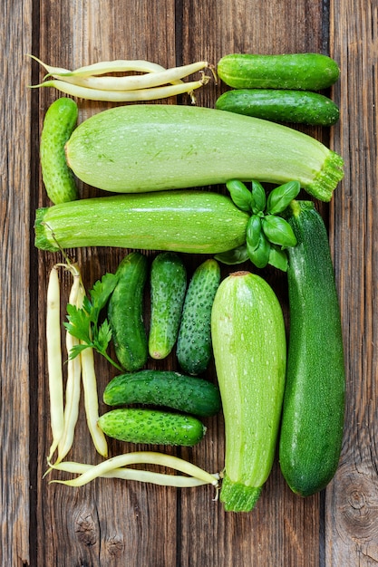 Nahaufnahmefoto des frischen organischen grünen Gemüses und des Grüns des Bauernhofes. Draufsicht auf Holzhintergrund