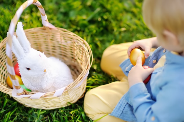 Nahaufnahmefoto des kleinen Jungen im Frühjahr jagend für Park Ostereies an Ostertag