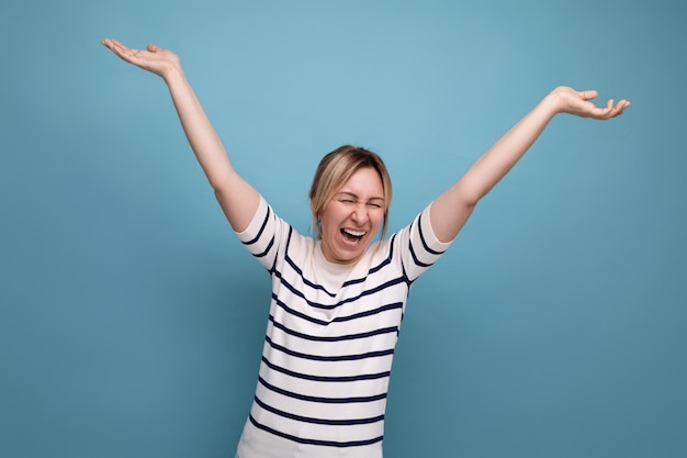 Nahaufnahmefoto einer entzückenden, energiegeladenen, glücklichen, blonden, tausendjährigen Frau in gestreifter Freizeitbluse auf Blau