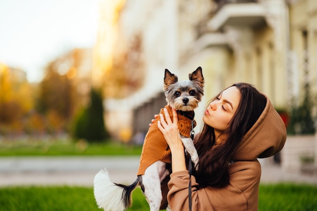 Nahaufnahmefoto einer Frau, die einen Biewer-Terrierhund hält und wegschaut