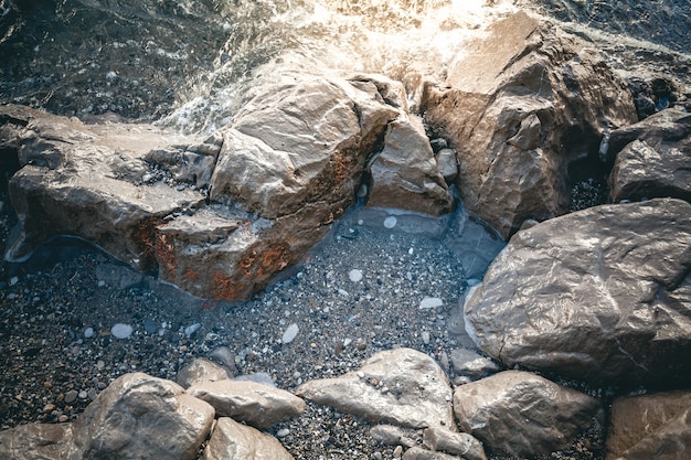 Foto nahaufnahmefoto von grauen felsen am meeresufer bei sonnenuntergang