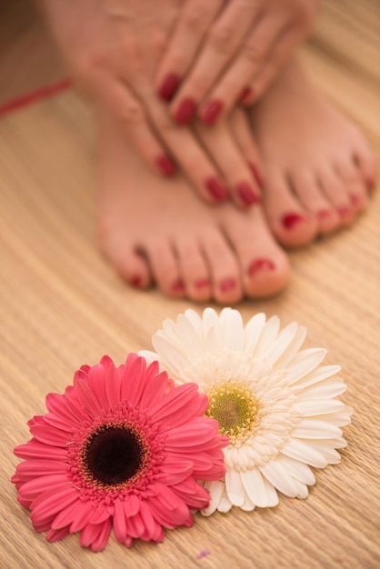 Nahaufnahmefoto von weiblichen Füßen und Händen im Spa-Salon bei Pediküre und Maniküre