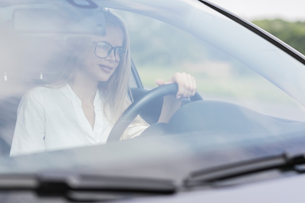 Nahaufnahmefrau, die das Auto fährt