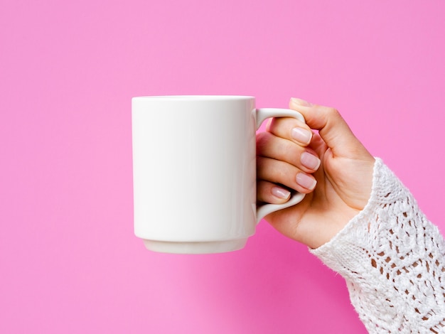 Nahaufnahmefrau mit Becher und rosa Hintergrund