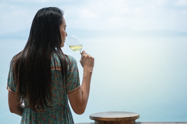 Nahaufnahmefrauen trinken Weißwein mit einem Glas Wein an der Terrasse auf Seeansicht