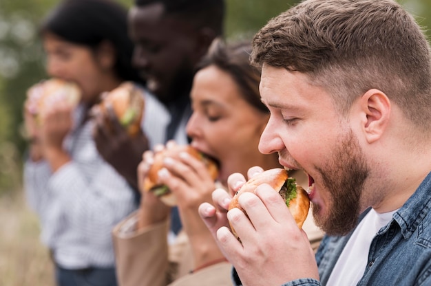 Nahaufnahmefreunde, die Burger zusammen essen