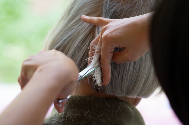 Nahaufnahmefriseur mit den Scheren, die Haar schneiden