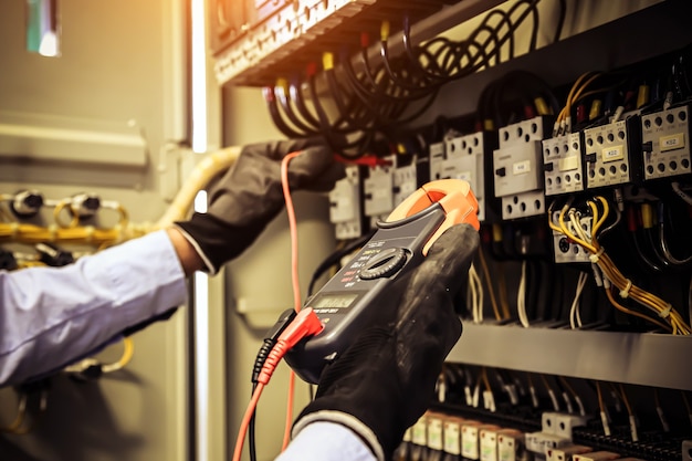 Foto nahaufnahmehand der elektrotechnik mit messung zur überprüfung der elektrizität.