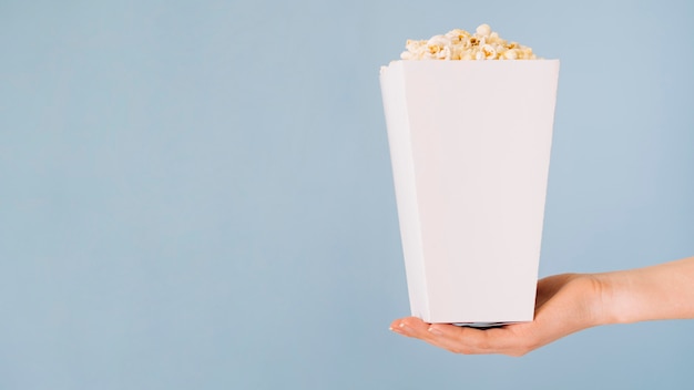 Nahaufnahmehand, die Popcornbox hält