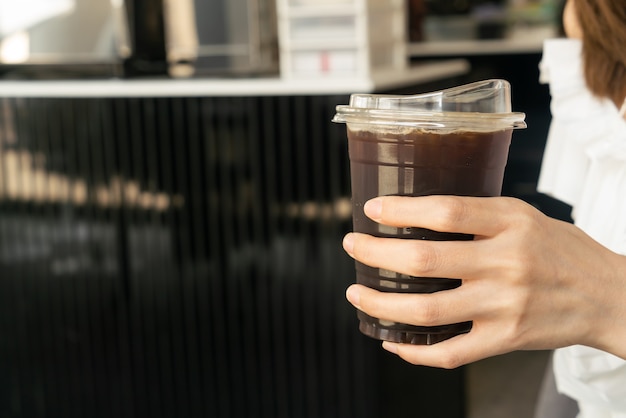 Nahaufnahmehand, die schwarze Kaffeetasse hält