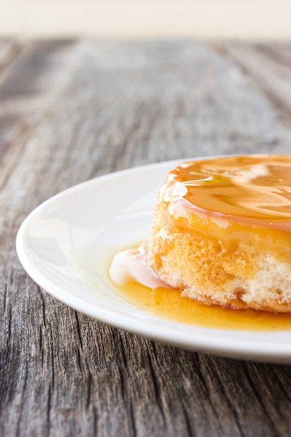 Foto nahaufnahmekaramelpuddingkuchen auf holztisch.