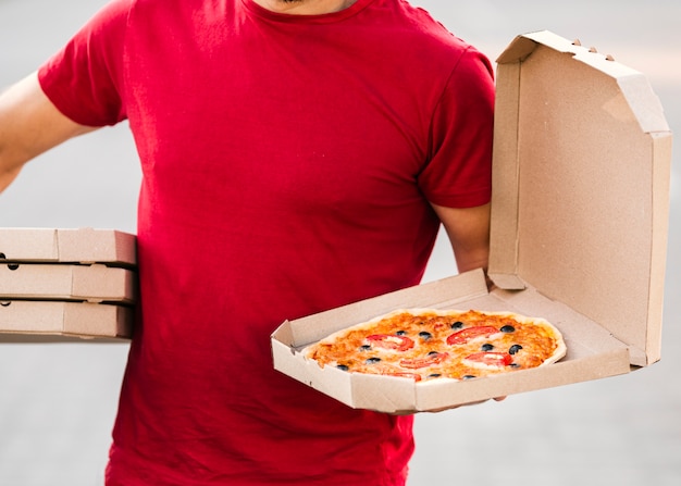 Foto nahaufnahmelieferant, der pizza hält
