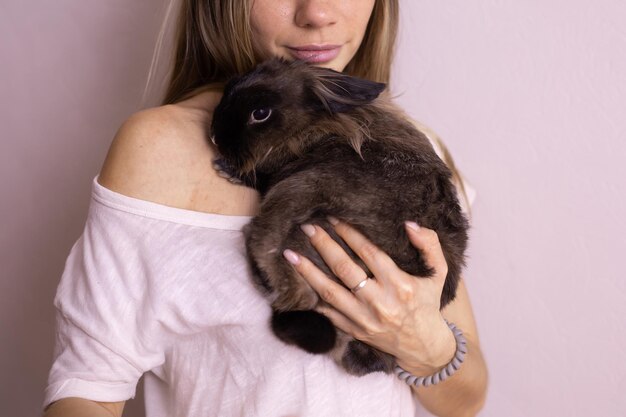 Nahaufnahmemädchen mit entzückendem Kaninchen zuhause schließen herauf reizendes Haustier- und Tierkonzept