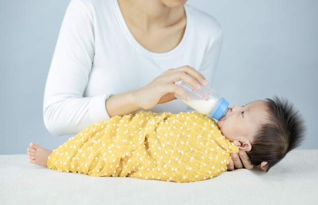 Nahaufnahmemutter, die Säuglingsbaby durch Flasche füttert