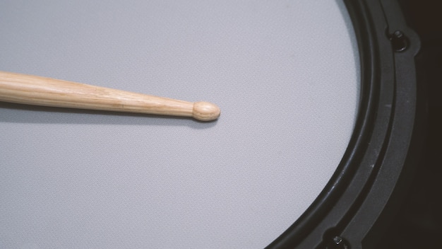 Foto nahaufnahmen von drumsticks auf elektronischem drum-snare-pad, das die wichtigste musikinstrumentalität ist